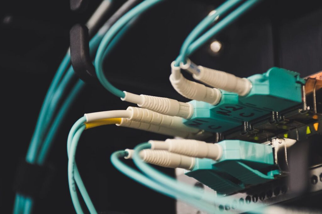 pexels-photo-1624895 Detailed view of fiber optic cables and ports in a server room, showcasing connectivity.